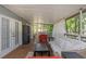 The covered porch with seating and doors that lead to the interior of the house at 403 Saint Petersburg W Dr, Oldsmar, FL 34677