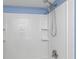 Bathroom shower features a double shower head, white tiling and corner shelving at 403 Saint Petersburg W Dr, Oldsmar, FL 34677