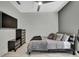 This bedroom has a TV, dresser, and bed with decorative pillows and is decorated with white and gray walls and white tile flooring at 4224 Crayford Ct, Land O Lakes, FL 34638