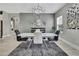 Chic dining room featuring a modern table, decorative mirror, unique chandelier, and gray color scheme at 4224 Crayford Ct, Land O Lakes, FL 34638