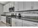 Well-lit kitchen features stainless steel appliances, granite counters, and sleek backsplash at 4224 Crayford Ct, Land O Lakes, FL 34638