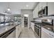 Modern kitchen with granite countertops, stainless steel appliances, white cabinetry, and open floor plan at 4224 Crayford Ct, Land O Lakes, FL 34638