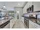 Gourmet kitchen features white cabinets, stainless steel appliances, and granite countertops at 4224 Crayford Ct, Land O Lakes, FL 34638