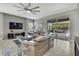 Bright living room with large sectional sofa, modern brick accent wall, and sliding glass doors to outdoor patio at 4224 Crayford Ct, Land O Lakes, FL 34638