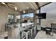 Covered outdoor kitchen featuring stainless steel appliances, island and bar seating at 4224 Crayford Ct, Land O Lakes, FL 34638