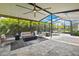 The spacious screened patio includes a cozy seating area with fireplace and an outdoor dining space with table and chairs at 4224 Crayford Ct, Land O Lakes, FL 34638