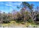 Scenic view of a green front yard featuring a white fence and picturesque mature oak trees at 4702 Cypress Serenity Dr, Plant City, FL 33565