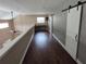 Loft hallway with hardwood floors and two sliding barn doors at 4702 Cypress Serenity Dr, Plant City, FL 33565