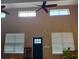 Bright, tall interior with high windows, ceiling fan, and black door framed by two windows at 4702 Cypress Serenity Dr, Plant City, FL 33565