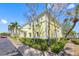Exterior view of a yellow building with green landscaping and palm trees on a sunny day at Coquina Key at 4740 Beach Se Dr # A, St Petersburg, FL 33705