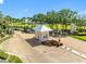 View of a community entrance with gate house, lush landscaping and brick paved drive at 4740 Beach Se Dr # A, St Petersburg, FL 33705