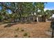 Exterior view of the home featuring a patio, lush trees, and a spacious backyard, perfect for entertaining at 4790 Shore Acres Ne Blvd, St Petersburg, FL 33703