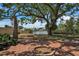 Beautiful backyard featuring mature trees, a brick patio, and a fire pit for outdoor enjoyment at 4790 Shore Acres Ne Blvd, St Petersburg, FL 33703