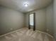 A simply styled bedroom showcasing neutral walls, light carpet, and a window with vertical blinds at 5221 Bannister Park Ln, Lithia, FL 33547