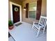 Inviting front porch with a rocking chair, a front door with a wreath, and large window at 5221 Bannister Park Ln, Lithia, FL 33547