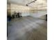 A spacious garage with concrete floors, overhead storage racks, and a rear access door at 5221 Bannister Park Ln, Lithia, FL 33547