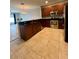 Modern kitchen with tile floors, stainless steel appliances, granite countertops and open to the living room at 5221 Bannister Park Ln, Lithia, FL 33547