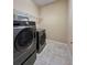 A modern laundry room equipped with a washer, dryer, and overhead shelving for organization at 5221 Bannister Park Ln, Lithia, FL 33547