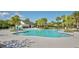 An inviting community pool with a splash pad, surrounded by lounge chairs and palm trees at 5221 Bannister Park Ln, Lithia, FL 33547