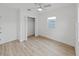 Bright bedroom with light LVP flooring, closet, and a window bringing in natural light at 5772 4Th N Ave, St Petersburg, FL 33710