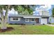 Charming one-story home featuring a blue exterior, white awning and a well-manicured front lawn at 5772 4Th N Ave, St Petersburg, FL 33710