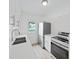 Modern white kitchen features stainless steel appliances, white cabinets and stone countertops at 5772 4Th N Ave, St Petersburg, FL 33710