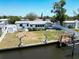 Back of white home on the water featuring a boat lift, covered patio, and minimal landscaping at 5812 Liverpool Dr, Tampa, FL 33615