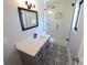 This bathroom features a glass shower, toilet, gray vanity, and black and white patterned floors at 5812 Liverpool Dr, Tampa, FL 33615