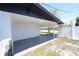 Spacious carport providing ample covered parking, complemented by a white exterior and a fenced yard at 5812 Liverpool Dr, Tampa, FL 33615