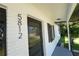 Close-up of the home's entrance showing a black door, freshly painted trim, and modern house number at 5812 Liverpool Dr, Tampa, FL 33615