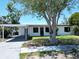 Exterior displaying a carport, a meticulously cared-for lawn, and a freshly painted facade at 5812 Liverpool Dr, Tampa, FL 33615