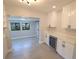 Modern kitchen with white cabinets, stainless steel wine cooler, and open access to the living room at 5812 Liverpool Dr, Tampa, FL 33615