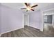Bedroom with wood-look floors, ceiling fan, closet, and view into adjacent room at 582 Royal Empress Dr, Ruskin, FL 33570