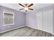 Bedroom features wood-look flooring, ceiling fan, and closet with double doors at 582 Royal Empress Dr, Ruskin, FL 33570