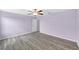 Bright bedroom with wood floors, purple walls, ceiling fan, and a large window offering scenic views at 582 Royal Empress Dr, Ruskin, FL 33570