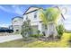 Two-story home showcasing an attached garage, a manicured lawn, and tropical landscaping at 582 Royal Empress Dr, Ruskin, FL 33570