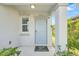 Covered front entrance featuring a neutral-colored door, welcome mat, and trimmed green plants at 582 Royal Empress Dr, Ruskin, FL 33570