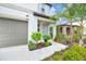 Home's front entrance with neutral-colored door, lush landscaping, and an attached garage at 582 Royal Empress Dr, Ruskin, FL 33570