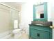 This bathroom features a teal vanity, a dark countertop and a glass enclosed shower at 6006 Laketree Ln # K, Temple Terrace, FL 33617
