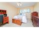 Bedroom with neutral walls, ceiling fan, a window and wood furniture, including a chest at the foot of the bed at 6006 Laketree Ln # K, Temple Terrace, FL 33617