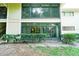 Condo exterior featuring large glass enclosed patios, trimmed shrubs, and natural surroundings at 6006 Laketree Ln # K, Temple Terrace, FL 33617