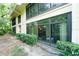 Multi-story condo with screened patios and large glass patio with trimmed green shrubs in front at 6006 Laketree Ln # K, Temple Terrace, FL 33617