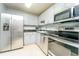 Modern kitchen features stainless steel appliances, granite countertops and white cabinets at 6006 Laketree Ln # K, Temple Terrace, FL 33617