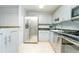 A bright white kitchen featuring stainless steel appliances, granite countertops and tile flooring at 6006 Laketree Ln # K, Temple Terrace, FL 33617