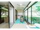 Relaxing sunroom features tile flooring, ceiling fan and floor to ceiling windows with views of mature trees and landscaping at 6006 Laketree Ln # K, Temple Terrace, FL 33617