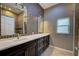 Bathroom featuring dual sinks with marble countertops, mosaic tile backsplash, and dark wood cabinets at 7333 Royal Oak Dr, Spring Hill, FL 34607
