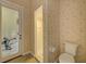 Bathroom featuring a glass door, neutral tiling and floral wallpaper at 7333 Royal Oak Dr, Spring Hill, FL 34607