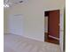 A bright bedroom with neutral carpet and white closet doors, leading to an adjoining room at 7333 Royal Oak Dr, Spring Hill, FL 34607