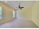 Bedroom features a ceiling fan, neutral carpet, and white closet doors and two windows at 7333 Royal Oak Dr, Spring Hill, FL 34607