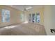 Spacious bedroom with neutral walls, plush carpeting, large windows, and access to patio at 7333 Royal Oak Dr, Spring Hill, FL 34607